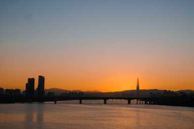Die ersten Sonnenstrahlen hinter dem Lotte Tower